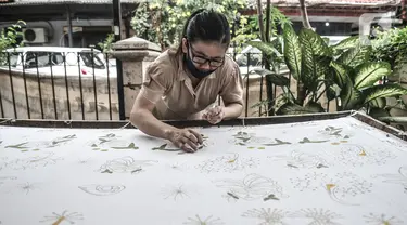 Pembatik disabilitas menyelesaikan karyanya di Rumah Batik Palbatu, Jakarta, Kamis (3/12/2020). Rumah Batik Palbatu mempercayakan kepada penyandang disabilitas binaannya untuk membuat kain batik, baik bercorak tradisional, temporer maupun perpaduan keduanya. (merdeka.com/Iqbal S. Nugroho)