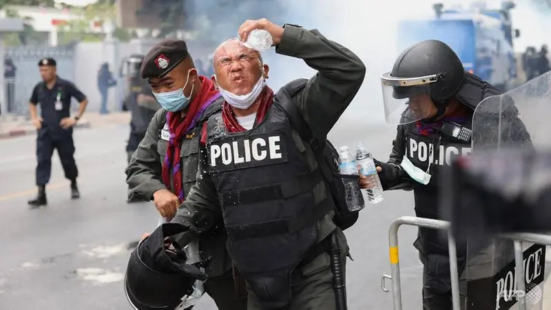 Seorang polisi bereaksi setelah gas air mata dilemparkan selama unjuk rasa anti-pemerintah di Bangkok pada 17 November 2020.