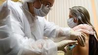 Perawat menyuntikkan vaksin corona Sputnik V di tengah pandemi yang sedang berlangsung di sebuah klinik di Moskow, Sabtu (5/12/2020). Presiden Rusia Vladimir Putin memerintahkan pihak berwenang memulai vaksinasi massal untuk orang-orang berisiko tinggi tertular Covid-19. (Kirill KUDRYAVTSEV/AFP)