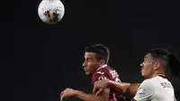 Pemain depan Torino, Alejandro Berenguer berebut bola dengan bek AS Roma, Chris Smalling pada pekan ke-37 Liga Italia di stadion Grande Torino di Turin, Rabu (29/7/2020). AS Roma berhasil mengalahkan tuan rumah Torino 3-2 meski sempat tertinggal lebih dulu. (Fabio Ferrari/LaPresse via AP)