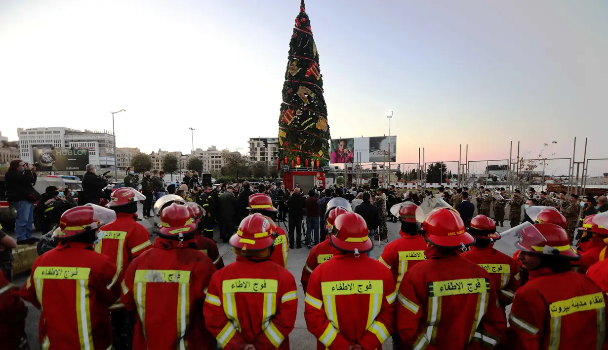Para petugas pemadam kebakaran mengikuti upacara pendirian pohon Natal di Beirut, Lebanon (20/12/2020). Pohon Natal ini didirikan ntuk mengenang para petugas pemadam kebakaran yang tewas dalam ledakan di Pelabuhan Beirut pada 4 Agustus lalu. (Xinhua/Bilal Jawich)