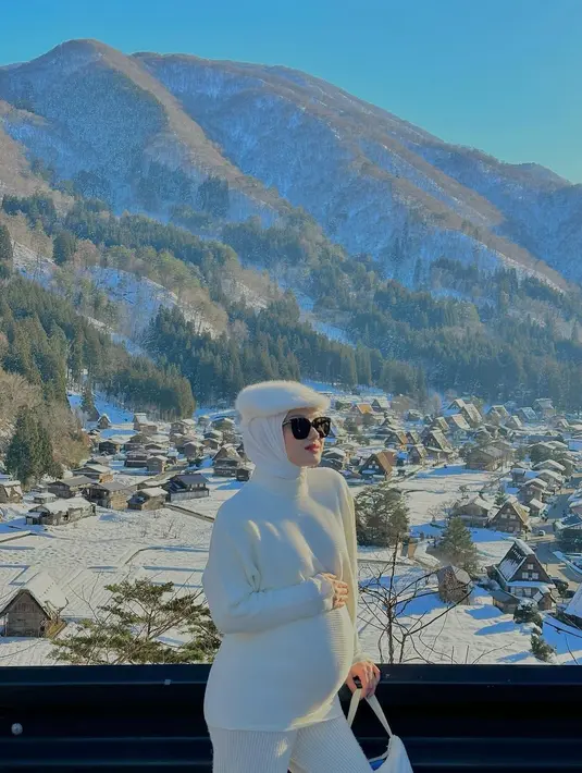 Turtleneck putih yang dipadu celana kulot warna senada beri kesan elegan pada tampilan bumil Dinda Hauw. @rey_mbayang.