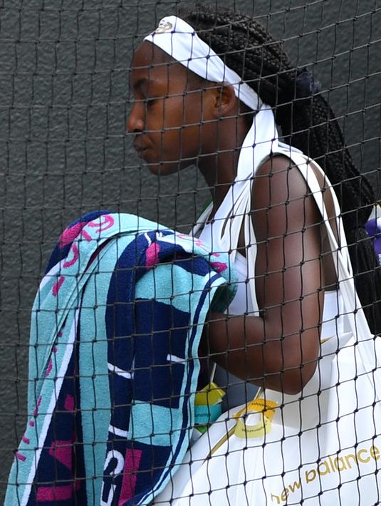 Petenis AS, Cori Gauff meninggalkan lapangan usai kalah atas petenis Rumania, Simona Halep pada babak keempat Wimbledon 2019 di All England Lawn Tennis Club, Senin (8/7/2019). Petenis berusia 15 tahun itu ditundukkan Halep, yang unggulan ke-7 turnamen, dengan skor 3-6, 3-6. (GLYN KIRK/AFP)