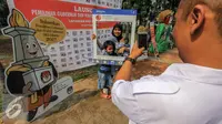 Warga berfoto menggunakan atribut saat launching pemilihan Gubernur dan Wakil Gubernur 2017 di Jakarta, Minggu (18/9). Launching tersebut bertujuan untuk mengedukasi masyarakat Jakarta menjelang Pilkada 2017. (Liputan6.com/Faizal Fanani)