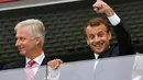 Presiden Prancis, Emmanuel Macron di samping Raja Belgia Philippe mengepalkan tangan ke udara saat menyaksikan laga semifinal Piala Dunia 2018 di St Petersburg Stadium, Selasa (10/7). Prancis sukses mengamankan satu tiket final. (AP/Martin Meissner)