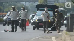 Petugas Satpol PP melakukan penyisiran Jalan Gatot Subroto dari ranjau paku di Jakarta, Sabtu (16/10/2021). Kegiatan penertiban ranjau paku ini untuk memberikan rasa aman dan nyaman bagi pengendara saat melintas di jalanan. (merdeka.com/Imam Buhori)