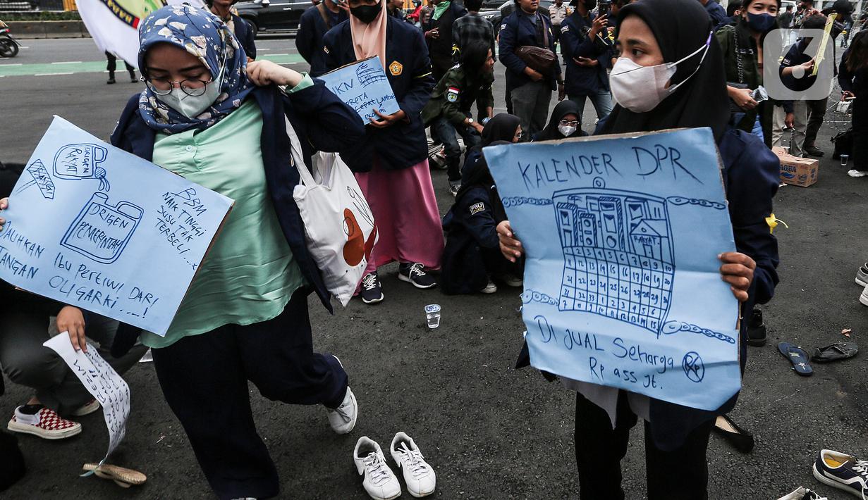 Mahasiswa membawa poster saat demo teatrikal di depan Gedung DPR/MPR RI, Jakarta Pusat, Jumat (9/9/2022). Demo tersebut untuk menolak kebijakan pemerintah menaikkan harga BBM. (Liputan6.com/Johan Tallo)