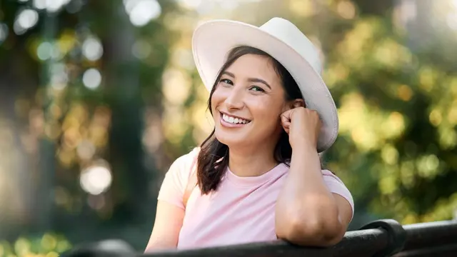tersenyum bahagia pakai topi