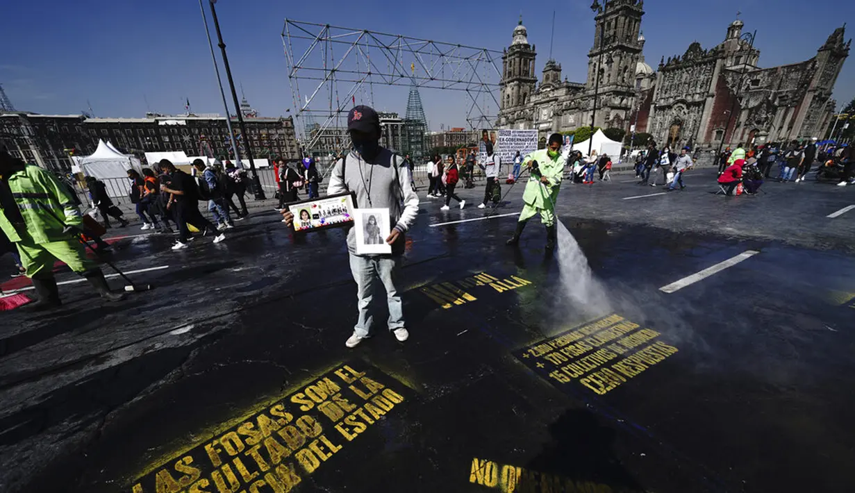 Pedro Cortes dari negara bagian Oaxaca memegang foto putrinya Belen Cortes (14 tahun) yang menghilang pada 1 Desember dari Zocalo saat dia bergabung dengan protes menuntut jawaban dari pemerintah tentang orang-orang yang hilang di Mexico City, Meksiko, 13 Desember 2021. (AP Photo/Marco Ugarte)