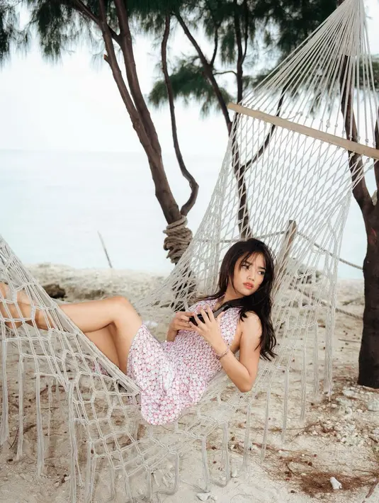 Ia memilih dress pendek bermotif bunga yang cantik dengan detail halter neck yang tak kalah manis. [Foto: Instagram/fuji_an]