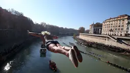 Seorang pria Italia bernama, Maurizio Palmulli melompat ke Sungai Tiber dari jembatan Cavour, Roma, Italia (1/1). Tradisi tahun baru di Italia ini sebelumnya pernah vakum, hingga akhirnya di rayakan kembali. (Reuters/Alessandro Bianchi)