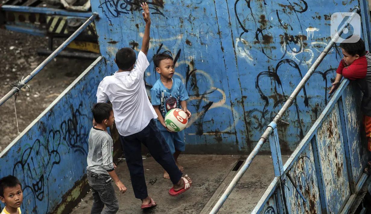 Sejumlah anak masuk ke dalam bak truk untuk bermain sepak bola, kawasan Cengkareng, Jakarta, Rabu (23/2/2022). Minimnya lahan bermain di kawasan tersebut membuat anak-anak memanfaatkan tempat yang bukan semestinya untuk bermain bola. (Liputan6.com/Johan Tallo)