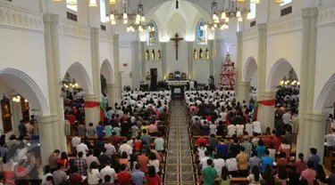 Para jemaat saat melakukan ibadah di Gereja Santo Laurensius, Alam Sutra, Tangerang, Kamis (24/12). Anggota kepolisian dan TNI berjaga disekitaran gereja untuk menanggulangi hal - hal yang tidak diinginkan. (Liputan6.com/Faisal R Syam)