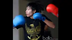 Seorang Karateka Putri dengan kaos bergambar garuda tengah berlatih mematangkan pukulan di Senayan, Jakarta, (Bola.com/Nicklas Hanoatubun)