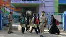 Polisi berjaga-jaga ketika siswa sekolah menengah negeri dan perguruan tinggi pra-universitas untuk wanita memasuki tempat institut pendidikan di Bangalore (16/2/2022). (AFP/Manjunath Kiran)