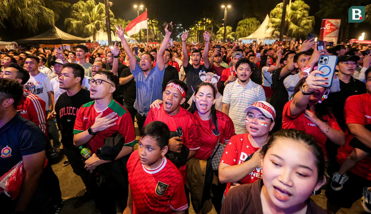 Pendukung Timnas Indonesia U-23 menyanyikan lagu kebangsaan Indonesia Raya saat nonton bareng Timnas Indonesia U-23 melawan Uzbekistan U-23 pada laga semifinal Piala Asia U-23 di Kompleks Stadion Utama Gelora Bung Karno (SUGBK), Senayan, Jakarta, Senin (29/04/2024) malam WIB. (Bola.com/Bagaskara Lazuardi)