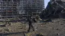 Seorang pria membawa sepedanya di tengah kerusakan setelah serangan sebuah pusat perbelanjaan di Kiev, Ukraina, Senin (21/3/2022). Delapan orang tewas dalam serangan tersebut. (AP Photo/Rodrigo Abd)