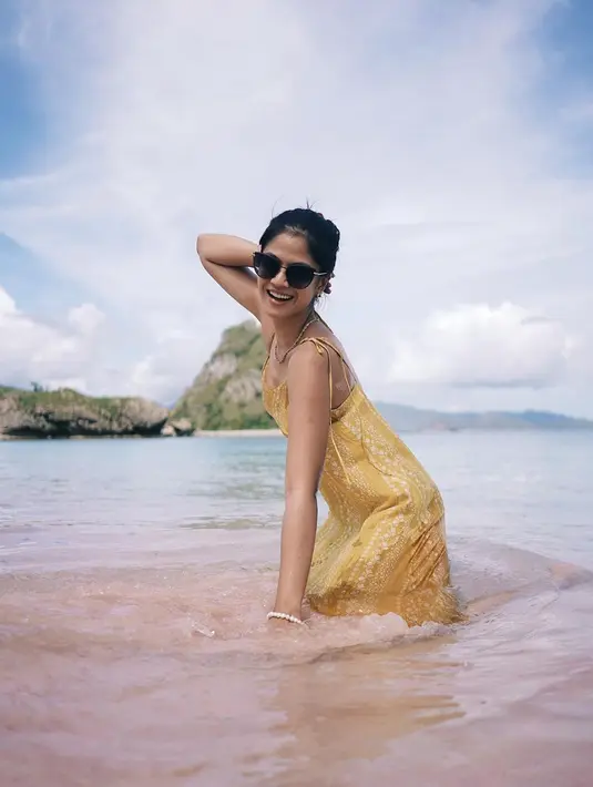 Raut wajah bahagia terlihat jelas dari Hana Saraswati saat sedang bermain air di Pink Beach, Pulau Komodo. Hana tak bisa menyembunyikan rasa takjubnya melihat warna pasir di pantai tersebut merah muda. Ketakjubannya terlihat dengan kerap memegang pasir merah muda di sana. (Liputan6.com/IG/@hananaho)