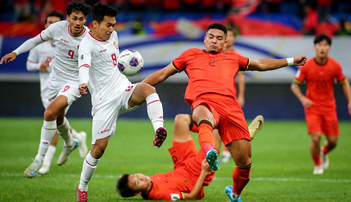 <p>Pemain Timnas Indonesia, Witan Sulaeman (kiri) berebut bola dengan pemain China,&nbsp;Jiang Guangtai (kanan) saat laga lanjutan putaran ketiga Grup C Kualifikasi Piala Dunia 2026 di Qingdao Youth Stadium, Qingdao, China, Selasa (15/10/2024). (AFP)</p>