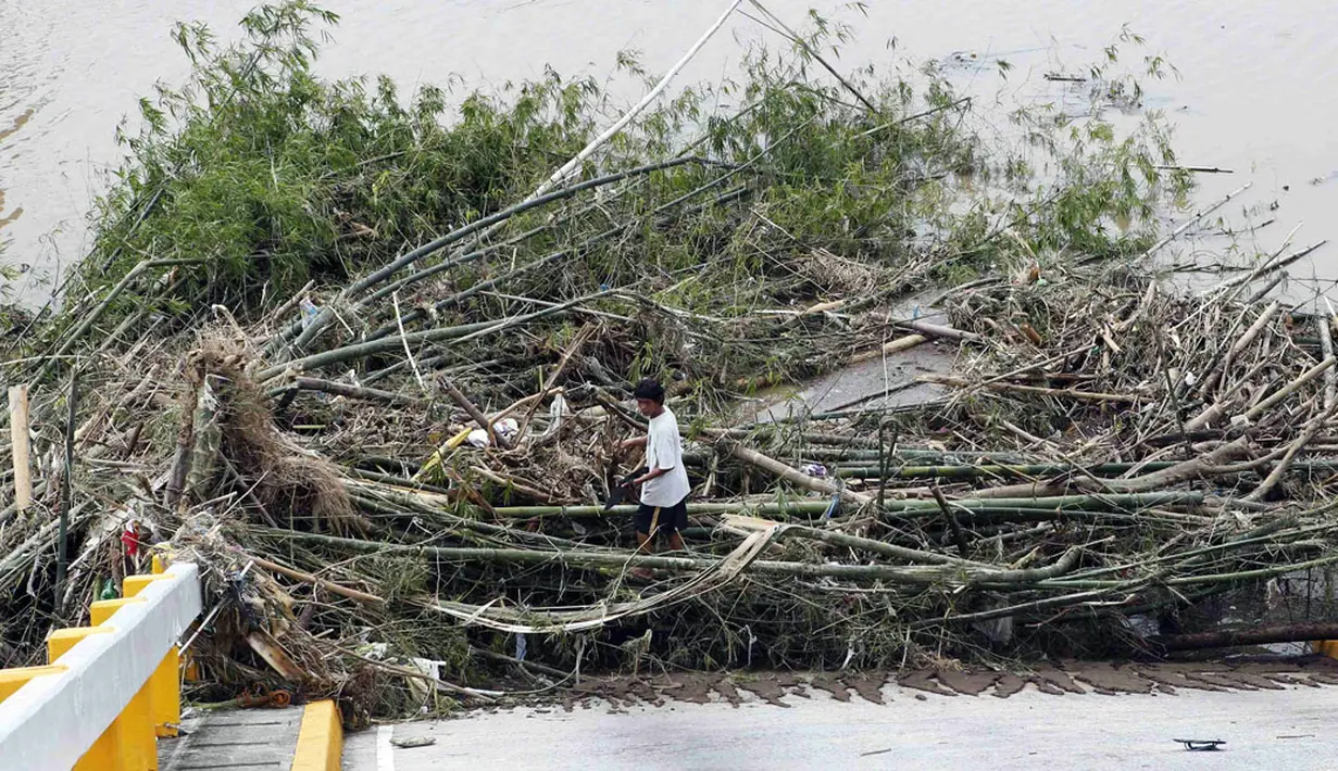 Salah satu pekerja bersiap membersihkan puing-puing di sebuah jembatan yang hancur saat serangan topan Rammasun, di Batangas, Manila, (17/7/2014). (REUTERS/Erik De Castro)
