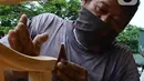 Pekerja menghaluskan furnitur atau perlengkapan rumah berbahan kayu dari Jepara di Ciputat, Tangerang Selatan, Selasa (14/9/2021). Pedagang di tempat tersebut mengakui selama PPKM ini daya beli masyarakat terhadap furnitur meningkat. (Liputan6.com/Johan Tallo)