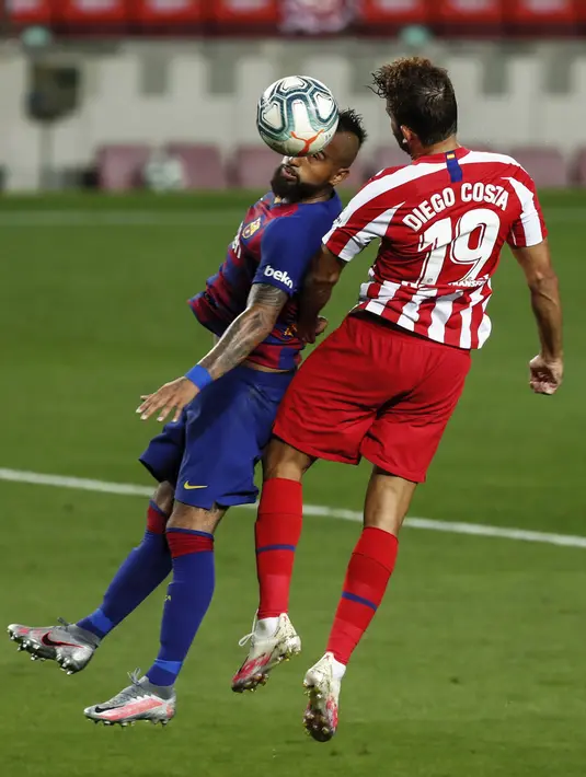 Pemain Barcelona Arturo Vidal (kiri) dan Atletico Madrid Diego Costa berebut bola udara pada pertandingan La Liga di Stadion Camp Nou, Barcelona, Spanyol, Selasa (30/6/2020). Barcelona bermain imbang 2-2 melawan Atletico Madrid. (AP Photo/Joan Monfort)