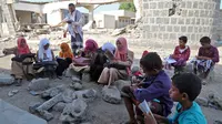 Anak-anak Yaman menghadiri kelas di luar ruangan sebuah sekolah yang rusak parah pada hari pertama tahun ajaran baru di provinsi barat Yaman yang dilanda perang Hodeida, Senin (17/10/2022). UNICEF memperkirakan bahwa lebih dari dua juta anak telah putus sekolah di Yaman, peningkatan hampir setengah juta sejak perang pecah pada 2015. (Foto oleh Khaled ZIAD / AFP).