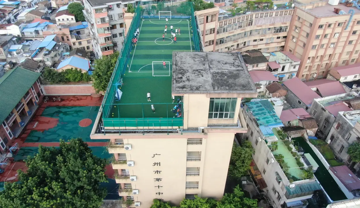 Foto udara pada 17 September 2020 menunjukkan lapangan olahraga di atas gedung Sekolah Menengah No.10 Guangzhou, China. Lapangan olah raga tersebut memiliki instalasi yang diperlukan seperti jaring pelindung, rumput sintetis, alat penerangan, dan sebagainya, di bagian atap gedung mereka. (Xinhua/Den