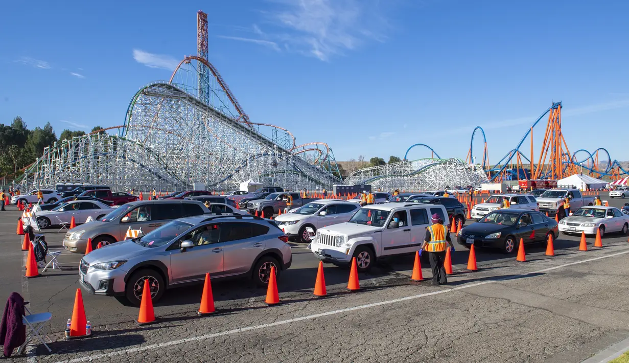 Orang-orang duduk di dalam mobil mereka di area observasi untuk memeriksa kemungkinan efek samping setelah mendapatkan suntikan vaksin di pusat vaksinasi Covid 19 skala besar yang didirikan di Six Flags Magic Mountain di Valencia, California, Selasa (2/2/2021). (VALERIE MACON/AFP)