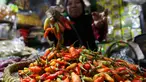 Pedagang menata cabai rawit dagangannya di pasar Cibubur, Jakarta, Rabu (6/12/2023). (Liputan6.com/Herman Zakharia)