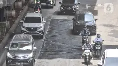 Kendaraan menghindari jalan rusak dan berlubang saat melintas di Jalan HR Rasuna Said, Kuningan, Jakarta Selatan, Senin (24/10/2022). Minimnya pengawasan dan perawatan dari pihak terkait menyebabkan jalan rusak dan berlubang imbas proyek pembangunan stasiun LRT Jabodebek tersebut sudah terjadi sejak dua bulan lalu yang dapat menimbulkan kecelakaan serta mengancam keselamatan pengendara. (merdeka.com/Iqbal S. Nugroho)