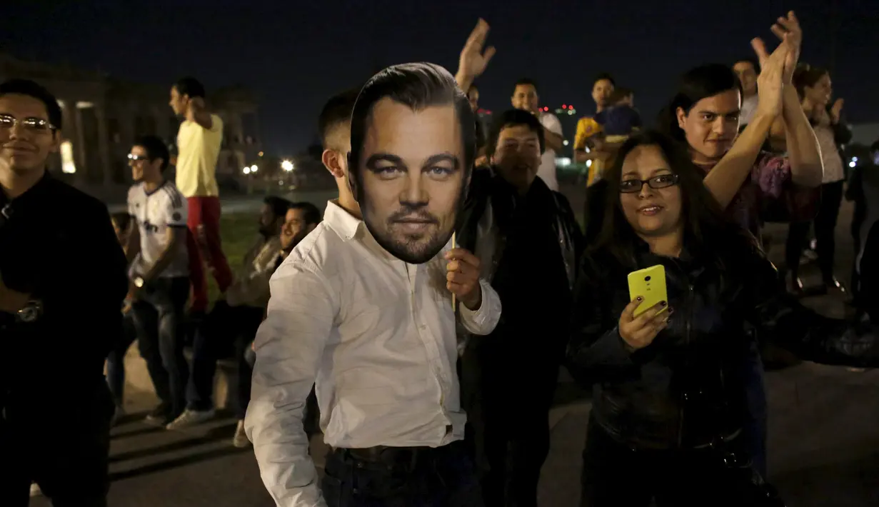 Fans memegang topeng Leonardo DiCaprio saat merayakan kemenangan sang idola sebagai Aktor Terbaik untuk film The Revenant pada ajang bergengsi Academy Awards ke-88 atau lebih dikenal Piala Oscar 2016, di Monterrey, Senin (29/2). (REUTERS/Daniel Becerril)