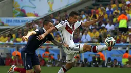 Pemain belakang Timnas Perancis, Mathieu Debuchy (kiri) berusaha menahan laju penyerang Jerman, Miroslav Klose saat berlaga di perempat final Piala Dunia 2014 di Stadion Maracana, Rio de Janeiro, (4/7/2014). (REUTERS/Pilar Olivares)
