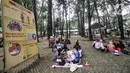 Wisatawan duduk di area dekat papan imbauan protokol kesehatan di Taman Margasatwa Ragunan, Jakarta, Jumat (14/5/2021). Taman Margasatwa Ragunan membatasi jumlah wisatawan dengan kapasitas 30 persen. (merdeka.com/Iqbal S. Nugroho)