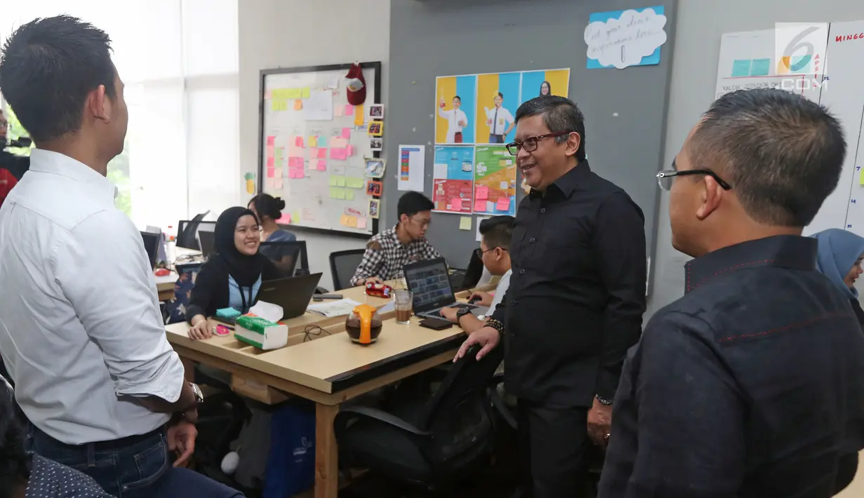 Sekjen PDIP Hasto Kristiyanto berbincang saaat melihat-lihat kantor ruangguru.com di Jakarta, Jumat (4/5). PDIP menunjuk Bupati Banyuwangi Abdullah Azwar Anas untuk memimpin proyek kerja sama dengan ruangguru.com. (Liputan6.com/Herman Zakharia)