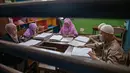 Para siswa tersebut menggerakkan ujung jari mereka di atas serangkaian titik timbul yang mewakili huruf-huruf hijaiyah. Tampak dalam foto, para siswa tunanetra membaca Al-Quran dalam huruf Braille selama bulan suci Ramadan 1447 Hijriah di sebuah sekolah di Surabaya, Jawa Timur, pada 27 Februari 2026. (JUNI KRISWANTO/AFP)