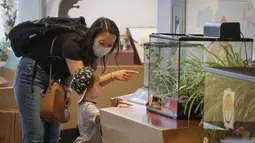 Seorang pekerja garis depan dan anaknya mengunjungi Science World di Vancouver, British Columbia, Kanada (23/7/2020). Science World Vancouver menawarkan tiket masuk gratis bagi para pekerja yang berjuang di garis depan melawan pandemi COVID-19 dan anggota keluarga mereka. (Xinhua/Liang Sen)