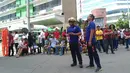 Pegawai kantor berkumpul di luar gedung setelah gempa bumi dahsyat  di Kota Davao, Filipina (29/10/2019). Lokasi gempa berada dekat Kota Kisante dan kurang dari 100 kilometer (60 mil) dari Kota Davao. Pada kedalaman Sekitar 50 kilometer (30 mil). (AP Photo)