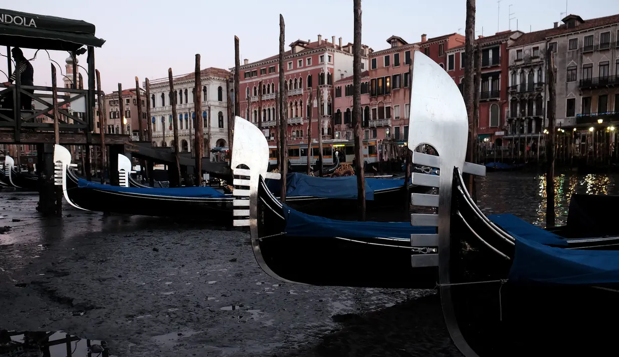 Perahu Gondola bersandar di laguna Venesia, Italia (29/12). Surutnya kanal ini mengakibatkan Gondola sulit berjalan dan banyak bersandar di pinggir Grand Canal di laguna Venesia, Italia. (REUTERS/Manuel Silvestri)