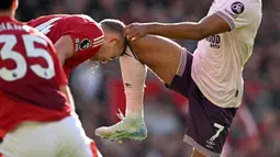 Pemain Manchester United, Matthijs de Ligt (kiri) berbenturan dengan lutut pemain Brentford, Kevin Schade saat laga lanjutan Liga Inggris 2024/2025 di Old Trafford, Manchester, Sabtu (19/10/2024). (AFP/Oli Scarff)