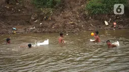 Anak-anak bermain di aliran Kali Ciliwung, Kampung Pulo, Jakarta, Jumat (2/12/2022). Anak-anak tetap bermain di sungai walaupun membahayakan keselamatan tanpa pengawasan orangtua, di mana dalam sepekan terakhir ini Jakarta diguyur hujan dengan intensitas curah hujan tinggi. (merdeka.com/Imam Buhori)