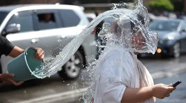 Orang-orang saling memercikkan air di pusat kota Yerevan selama liburan tahunan Vardavar pada 16 Juli 2023. (Photo by Karen MINASYAN / AFP)