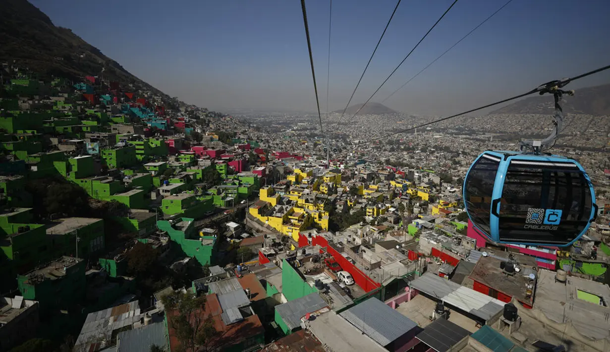 Pejabat dan jurnalis naik kereta gantung antara Stasiun Campos Revolucion dan Tlalpexco selama peresmian sistem angkutan umum udara baru yang disebut Cablebus di lingkungan Cuautepec, utara Mexico City, Meksiko, Kamis (4/3/2021). (AP Photo/Rebecca Blackwell)