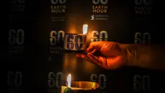 Seorang aktivis menyalakan lilin dalam sebuah acara untuk menandai kampanye lingkungan Earth Hour di Surabaya pada 23 Maret 2024. (JUNI KRISWANTO/AFP)