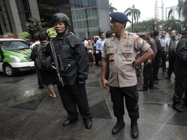 Petugas kepolisian bersenjata berjaga di sekitar lokasi Gedung BEI, Jakarta, Senin (15/1). Demi keamanan dan keselamatan, pihak keamanan menutup area sekitar lokasi gedung BEI yang ambruk. (Liputan6.com/Arya Manggala)