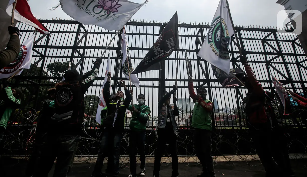 Pengemudi ojek online yang tergabung dalam Koalisi Ojol Nasional menggelar aksi di depan Gedung DPR RI, Jakarta, Senin (29/8/2022). Ratusan pengemudi ojek online tersebut menuntut beberapa hal di antaranya payung hukum dan legalitas profesi ojek online serta revisi potongan komisi pendapatan mitra. (Liputan6.com/Faizal Fanani)