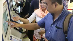 Petugas membantu pengguna transportasi kereta Bandara Soetta saat menggunakan kartu Perfeq Rider di Jakarta, Kamis (7/6). Kartu Perfeq Rider memberikan harga khusus mulai dari Rp 35 ribu-Rp50 ribu untuk satu kali berangkat. (Liputan6.com/Angga)