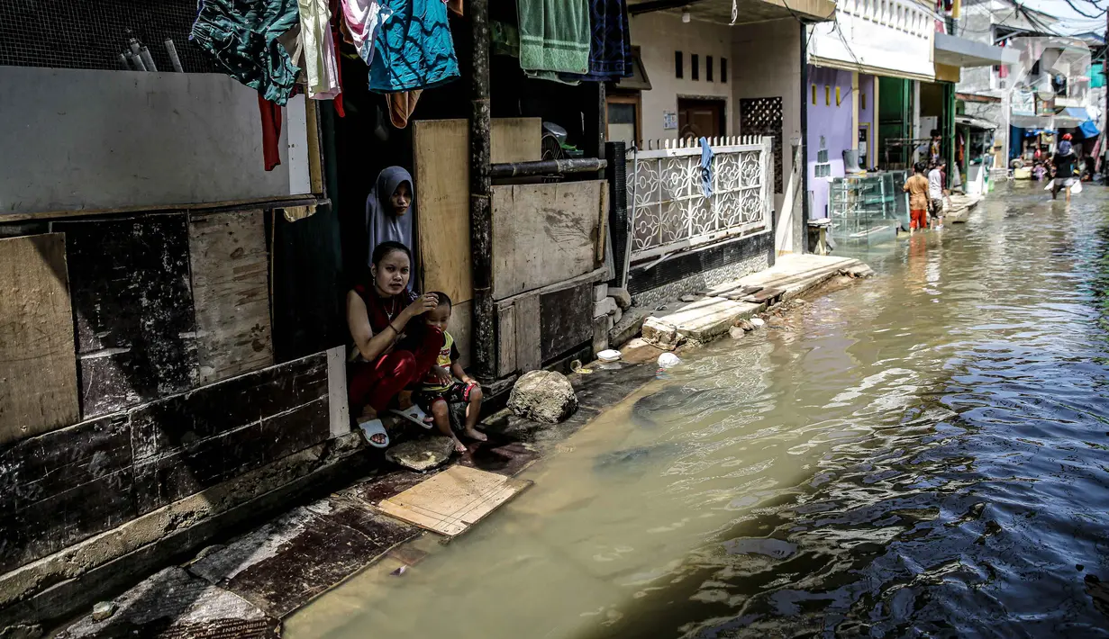 Aktivitas warga saat banjir rob di kawasan Muara Angke, Jakarta, Selasa (9/11/2021). Badan Penanggulangan Bencana Daerah (BPBD) DKI Jakarta memperkirakan puncak musim hujan dan potensi rob di Ibu Kota terjadi pada Januari hingga Februari 2022. (Liputan6.com/Faizal Fanani)