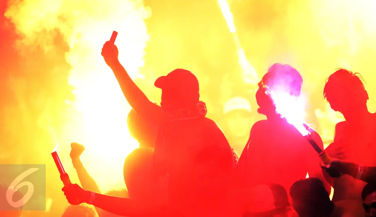 Suporter tim Maung Bandung bersorak sambil menyalakan suar usai menyaksikan laga Persib melawan Mitra Kukar FC di babak 8 besar Piala Presiden 2017 di Stadion Manahan, Solo, Sabtu (25/2). Persib lolos ke semifinal. (Liputan6.com/Helmi Fithriansyah) 