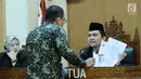 Ketua Majelis sidang sengketa informasi publik terhadap Kementerian LHK, Hendra J Kede (kanan) memeriksa kelengkapan berkas bersama asisten bantuan hukum LBH Jakarta, Abraham Nempung di Gedung KIP, Jakarta, Kamis (1/3). (Liputan6.com/Helmi Fithriansyah)